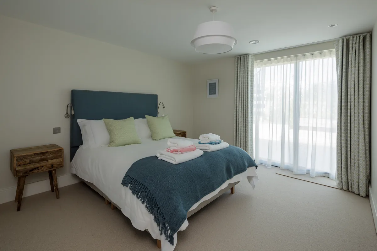 Bedroom one — king bed, en-suite, patio doors to the courtyard
