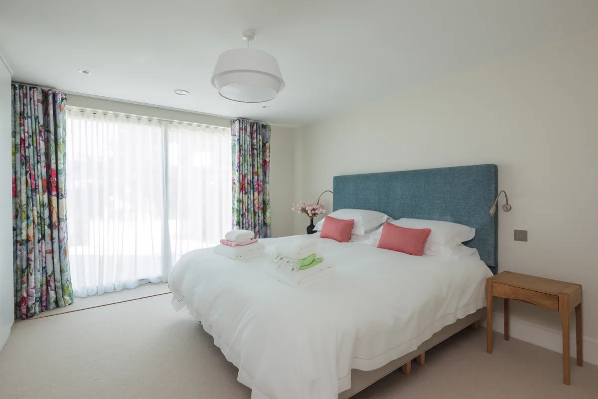 Bedroom two — king bed, en-suite, patio doors to the courtyard