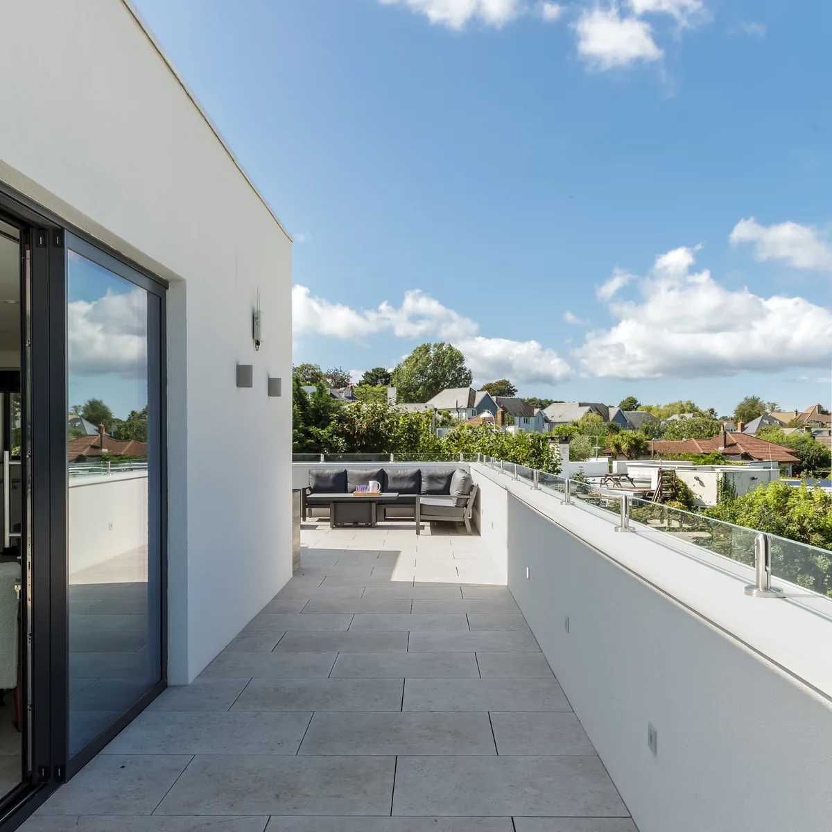The terrace with its corner sofa, looking out over rooftops towards the water